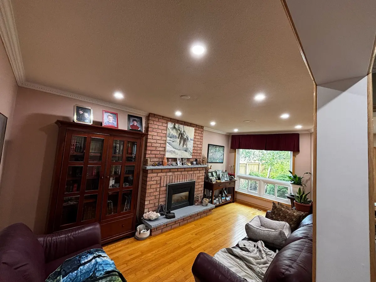 Modern recessed pot light layout in an older Richmond Hill living room with fireplace